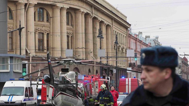 Members of Emergency services stand next to helicopter outside Tekhnologicheskiy institut metro station in St. Petersburg