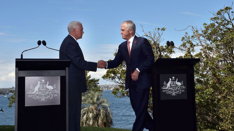 Mike Pence (L) and Malcolm Turnbull (R) shake hands on the shores of Sydney Harbour