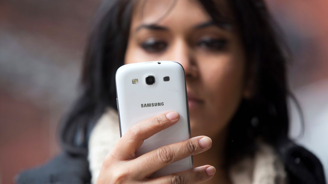 A woman uses a mobile phone in north London February 20, 2013