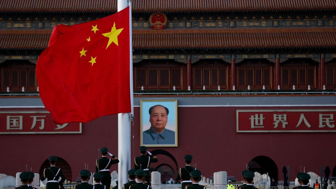 Chinese paramilitary policemen perform a flag lowering ceremony in Tiananmen Square