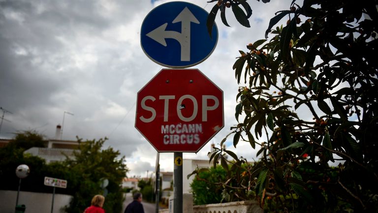 People pass by a stop sign that was vandalised with the message &#39;STOP McCann Circus&#39; in Praia da Luz in Algarve, southern Portugal, on April 28, 2017