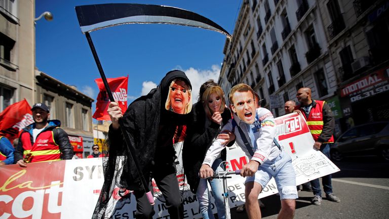 Protesters wearing masks depicting Emmanuel Macron and Marine Le Pen in Paris