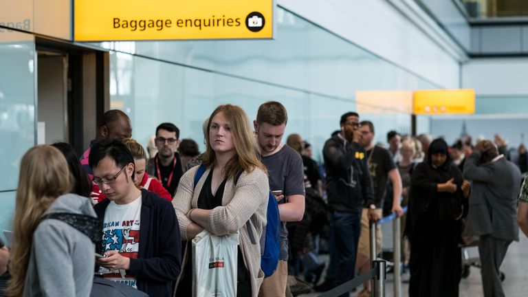 People queue to speak to British Airways representatives at Heathrow Airport Terminal 5