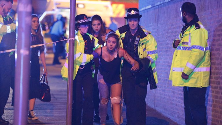 An injured concert goer is helped away from the Manchester Arena