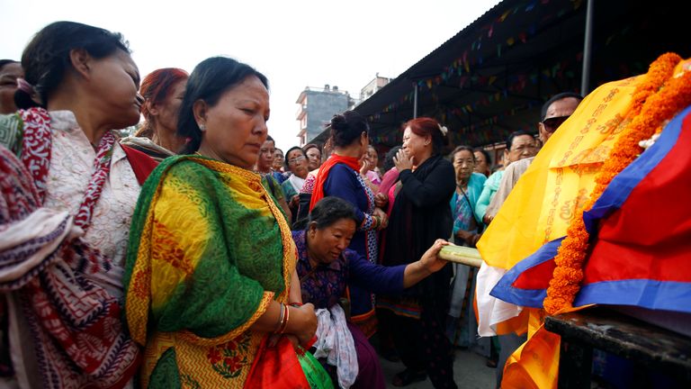 At his funeral, supporters offered flowers and scarves as Buddhist monks chanted a hymn