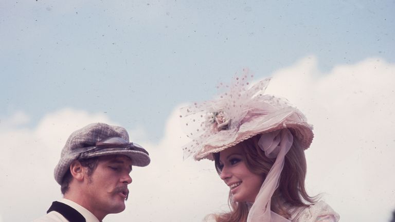 1968: Sir Roger Moore filming in the grounds of Woburn Abbey with his Italian co-star, Claudie Lange, for the film &#39;Crossplot&#39;
