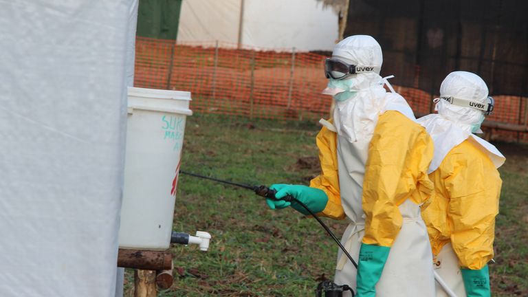 Hygienists wearing protective suits disinfect the toilets of the Ebola treatment centre in Lokolia, on October 5, 2014