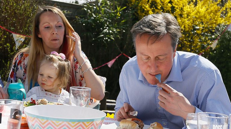 Prime Minister David Cameron speaks with Lilli Docherty and her daughter Dakota, as he has lunch with people who have benefited from tax and pension changes that come into force, in a garden on April 6, 2015 near Poole, England. Britain goes to the polls for a general election on May 7