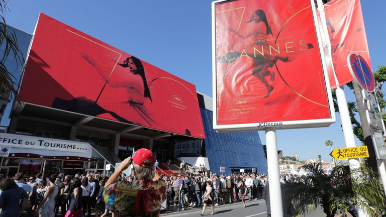 A tourist takes a photo of the official poster, featuring actress Claudia Cardinale