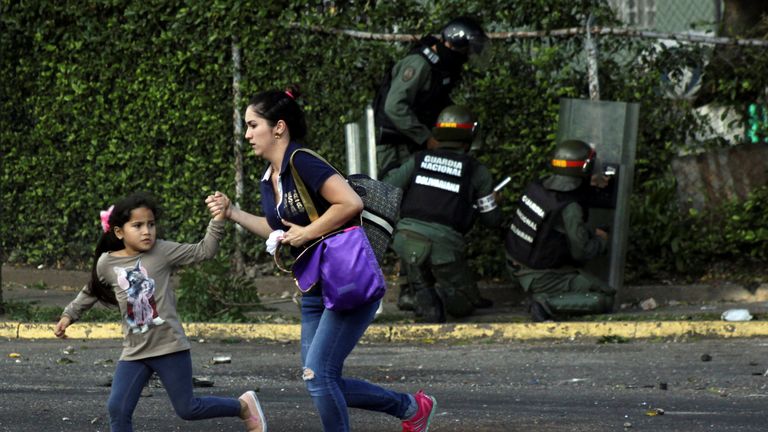 A woman and a girl run away as riot security forces and demonstrators clash during a protest against Venezuela&#39;s President Nicolas Maduro&#39;s government in Tariba, Venezuela
