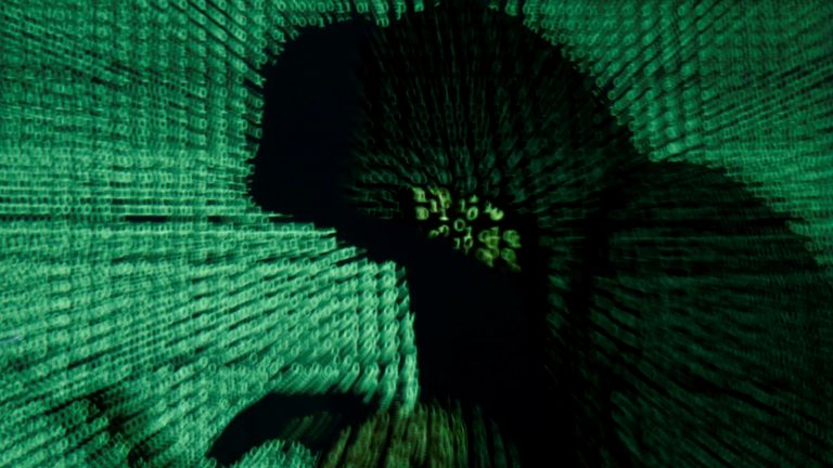 A man holds a laptop computer as cyber code is projected on him in this illustration picture taken on May 13, 2017. Capitalizing on spying tools believed to have been developed by the U.S. National Security Agency, hackers staged a cyber assault with a self-spreading malware that has infected tens of thousands of computers in nearly 100 countries. REUTERS/Kacper Pempel/Illustration