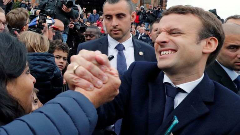 Emmanuel Macron greets supporters as leaves a polling station in Le Touquet