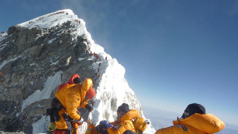 Climbers pause on the Hillary Step before going to the summit of Mount Everest