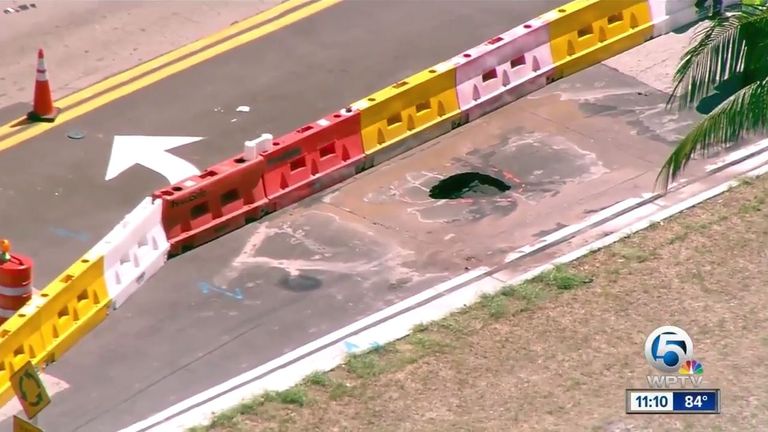 The sinkhole in the road next to the estate. Pic: NBC News