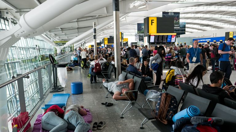 People sleep at Heathrow Airport as a British Airways IT chaos affected 75,000 flights