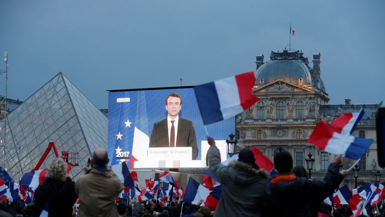 Emmanuel Macron is seen on a giant screen after the results were announced