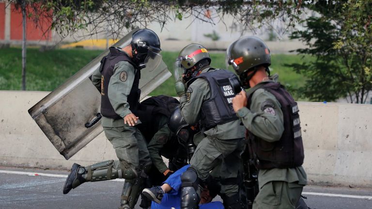 An opposition supporter is detained by riot police during a rally against President Nicolas Maduro in Caracas