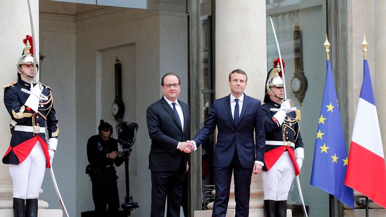 Francois Hollande greets Emmanuel Macron at the Elysee Palace
