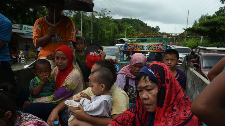 Evacuees from Marawi city are checked by police before entering Iligan city in the Philippines