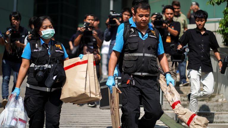 Forensic police carry evidence away from the scene of the explosion in Bangkok