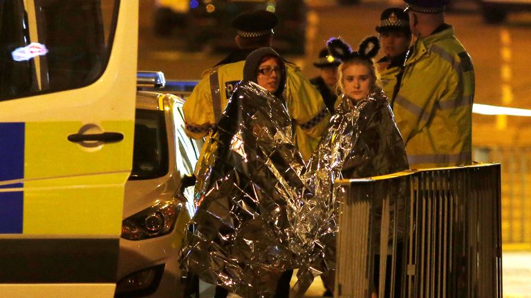 Two concert goers are wrapped in thermal blankets after the concert