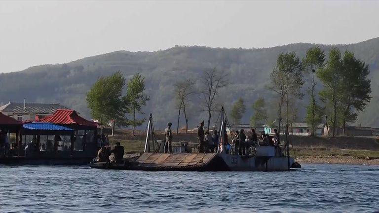 An ageing passenger ferry and a Chinese tourist boat on the Yalu River