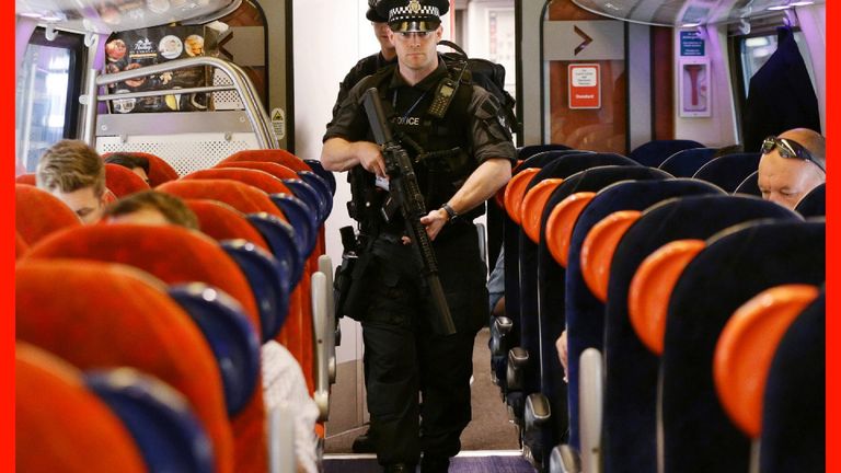 Firearms officers with the British Transport Police disembark trains at London Euston.