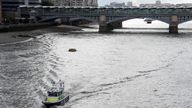 A police boat heads along the River Thames towards London Bridge