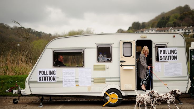 A woman leaves with her dogs after voting in a caravan converted into a polling station in Cornwall, south-west England, on May 6, 2010