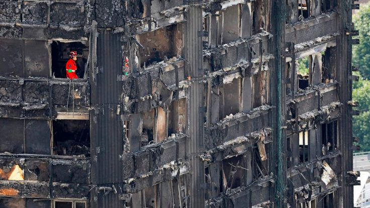 Members of the emergency services work on the middle floors of the charred remains of Grenfell Tower 