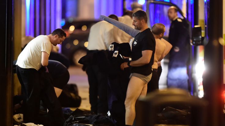 Police officers change into protective clothing as they attend to an incident on London Bridge