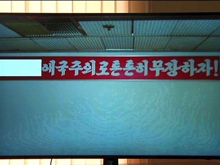 The propaganda sign Mr Warmbier attempted to take from his hotel