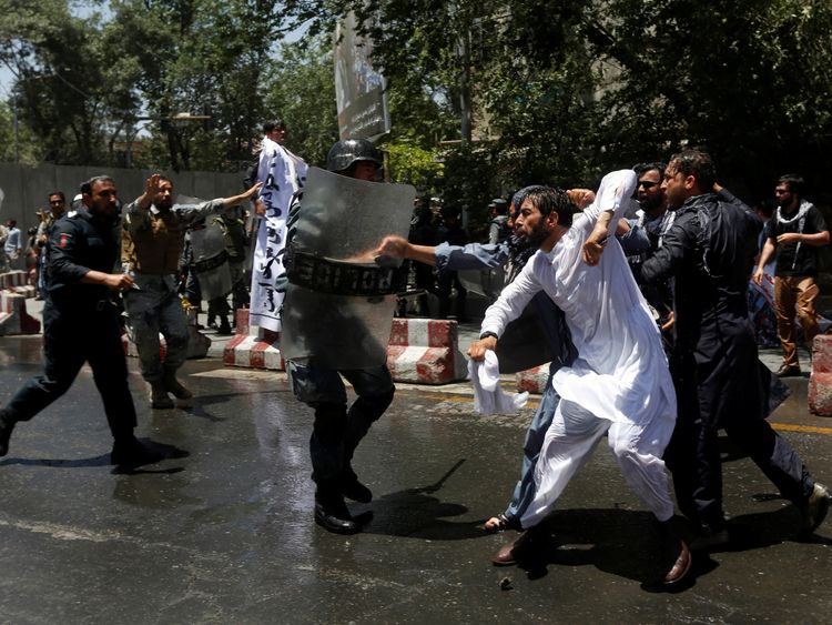 Riot police clash with people protesting about a huge bomb attack in Kabul