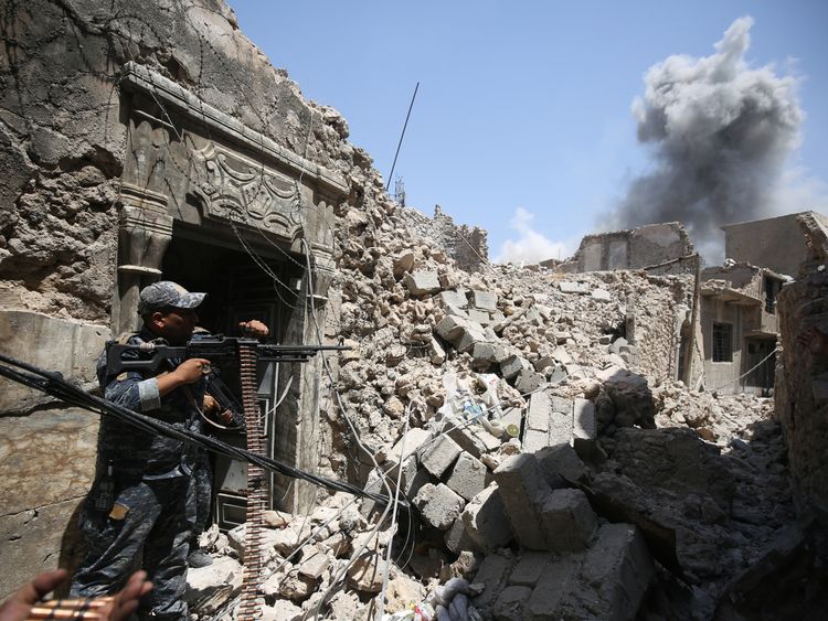 Members of the Iraqi federal police hold position during an armed exchange while advancing through the Old City of Mosul