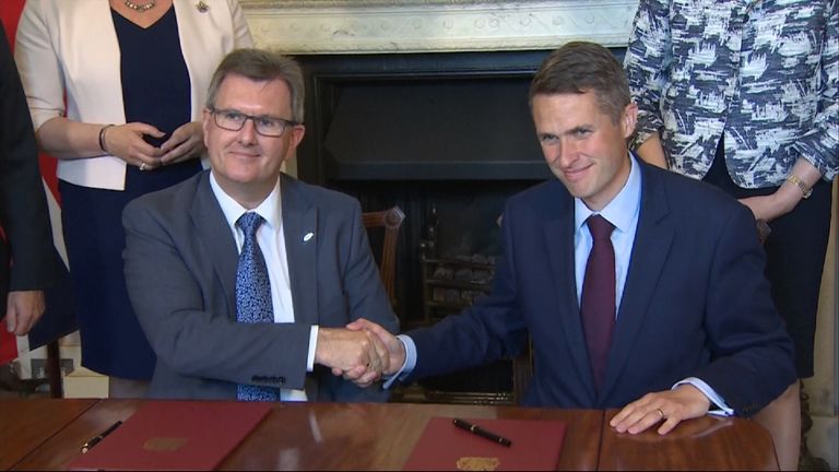 Sir Jeffrey Donaldson (L) and Gavin Williamson (R) shaking hands after signing the document