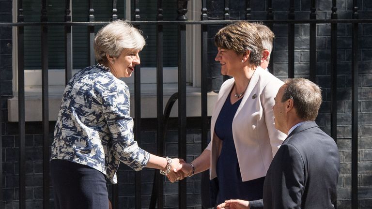Theresa May and Arlene Foster shake hands shortly before striking a deal
