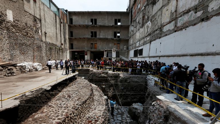 An archaeologist talks to the media at the site of the temple and adjacent ball court
