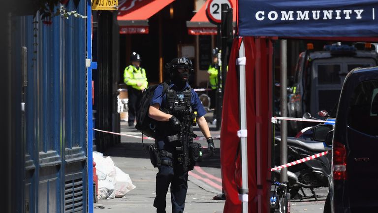 A counter terrorism officer walks near Tapas Brindisa restaurant at Borough Market 