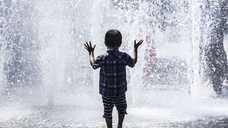 A child plays in a water fountain in Bradford on the hottest day of the year