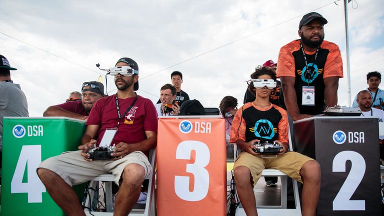 Sorell Miller (R), 12, uses a remote control and cockpit view goggles as he flies his drone during practice day at the National Drone Racing Championships on Governors Island, August 5, 2016 in New York City
