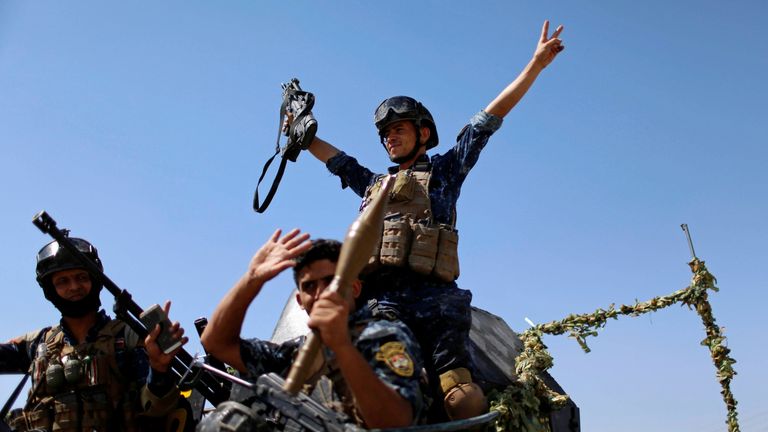 Members of the Iraqi Federal Police gesture after returning back from the front line in the Old City of Mosul