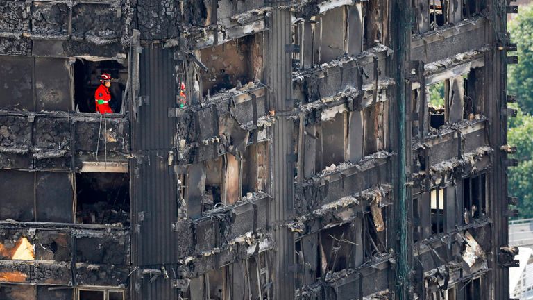 Members of the emergency services work on the middle floors of the charred remains of Grenfell Tower 