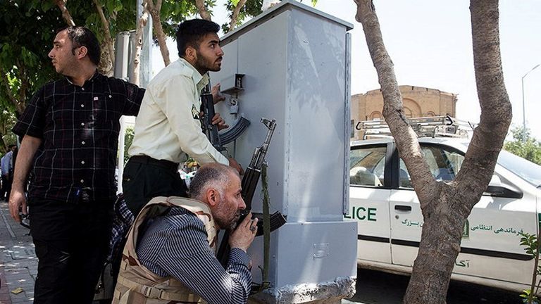 Members of Iranian forces take cover during an attack on the Iranian parliament 