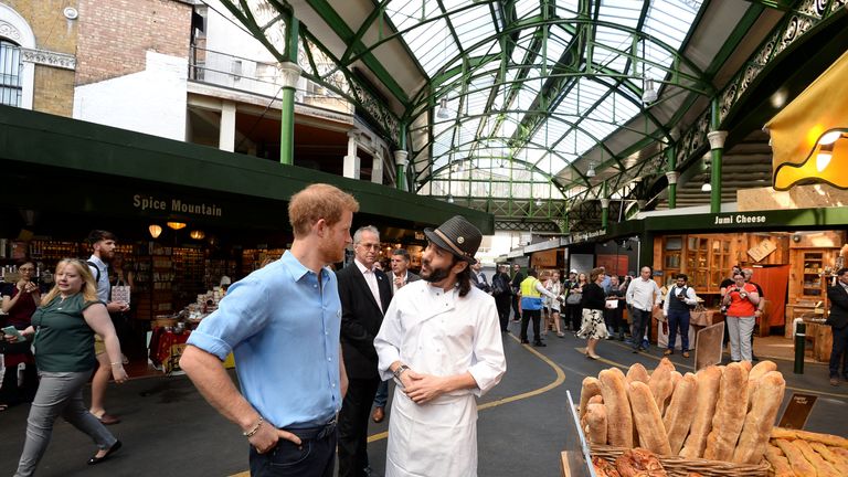 Prince Harry speaks to Matthew from the Bread Ahead stall during a visit to Borough Market, which has officially opened following the London Bridge attack