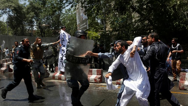 Riot police clash with people protesting about a huge bomb attack in Kabul
