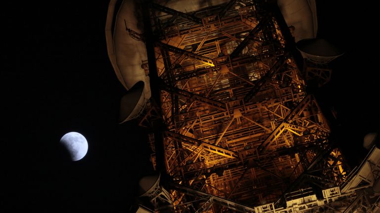 A partial lunar eclipse seen from behind the Tokyo tower, Japan