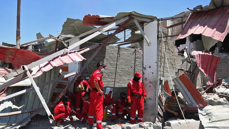 Iraqi civil defence search and rescue workers rest as they look for the bodies of victims under the rubble of buildings