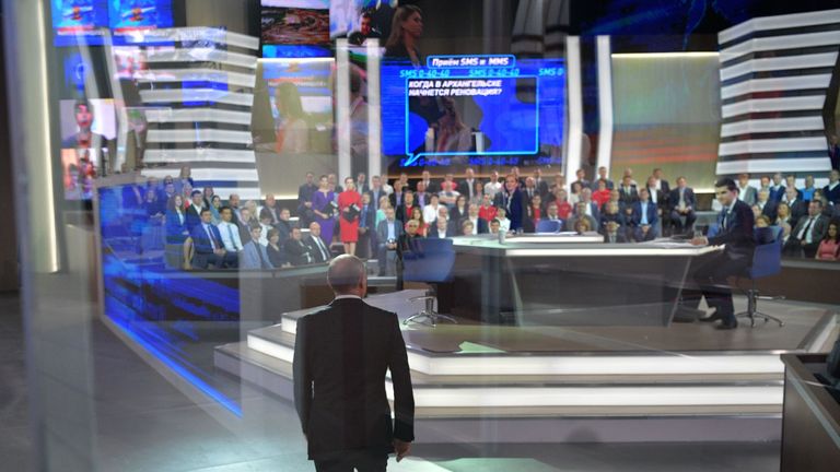 Russian President Vladimir Putin (C) arrives at the Gostiny Dvor studio for the annual 'Direct Line with Vladimir Putin broadcast live' by Russian TV channels and radio stations in Moscow on June 15, 2017