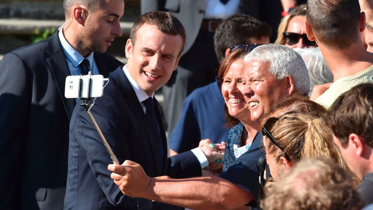 French President Emmanuel Macron (L) poses for a selfie picture with a supporter as he leaves his house to vote in Le Touquet, northern France, during the second round of the French parliamentary elections (elections legislatives in French), on June 18, 2017. / AFP PHOTO / Philippe HUGUEN (Photo credit should read PHILIPPE HUGUEN/AFP/Getty Images)