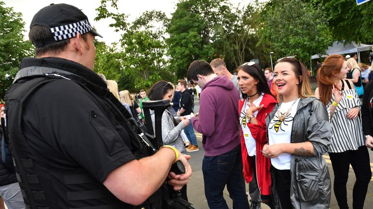 Two women share a laugh with an armed police officer